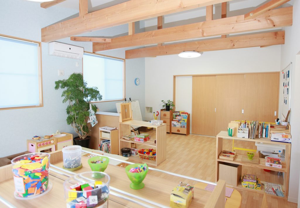 Organized and Light-Filled Classroom – Discovery International School Nagoya A bright, organized international preschool classroom at Discovery International School in Nagakute, Nagoya, Japan. The photo shows open shelves with educational materials, colorful manipulatives, and a cozy, Reggio Emilia-inspired environment for early childhood learning.