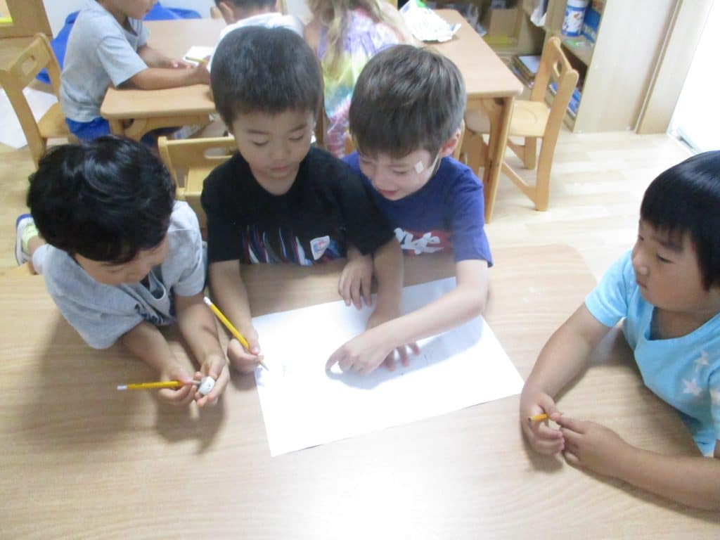 Students help each other on a phonics lesson