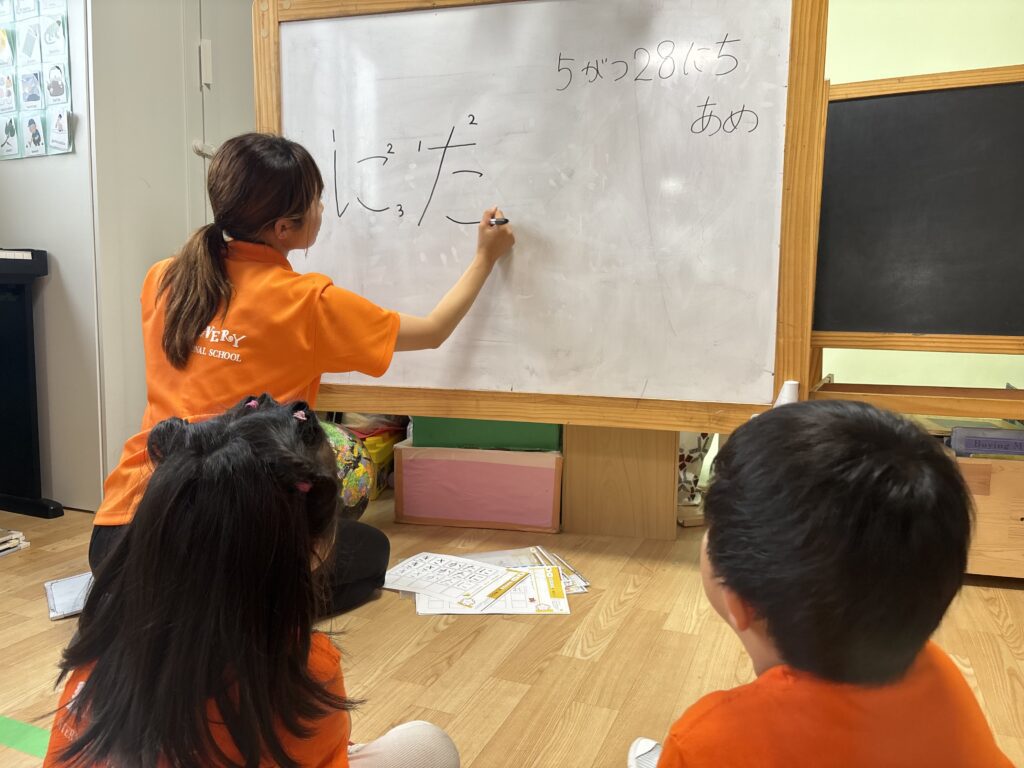 Kindergarten Japanese writing class at international school in Nagoya A teacher demonstrates hiragana stroke order during Japanese class at a preschool international school in Nagoya
