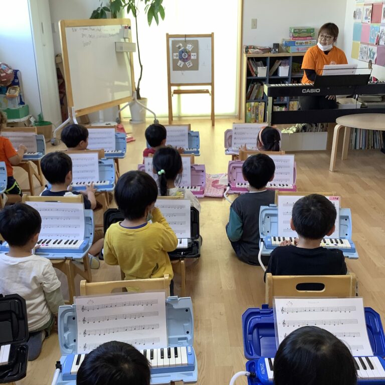 International school children playing pianica in their music class.