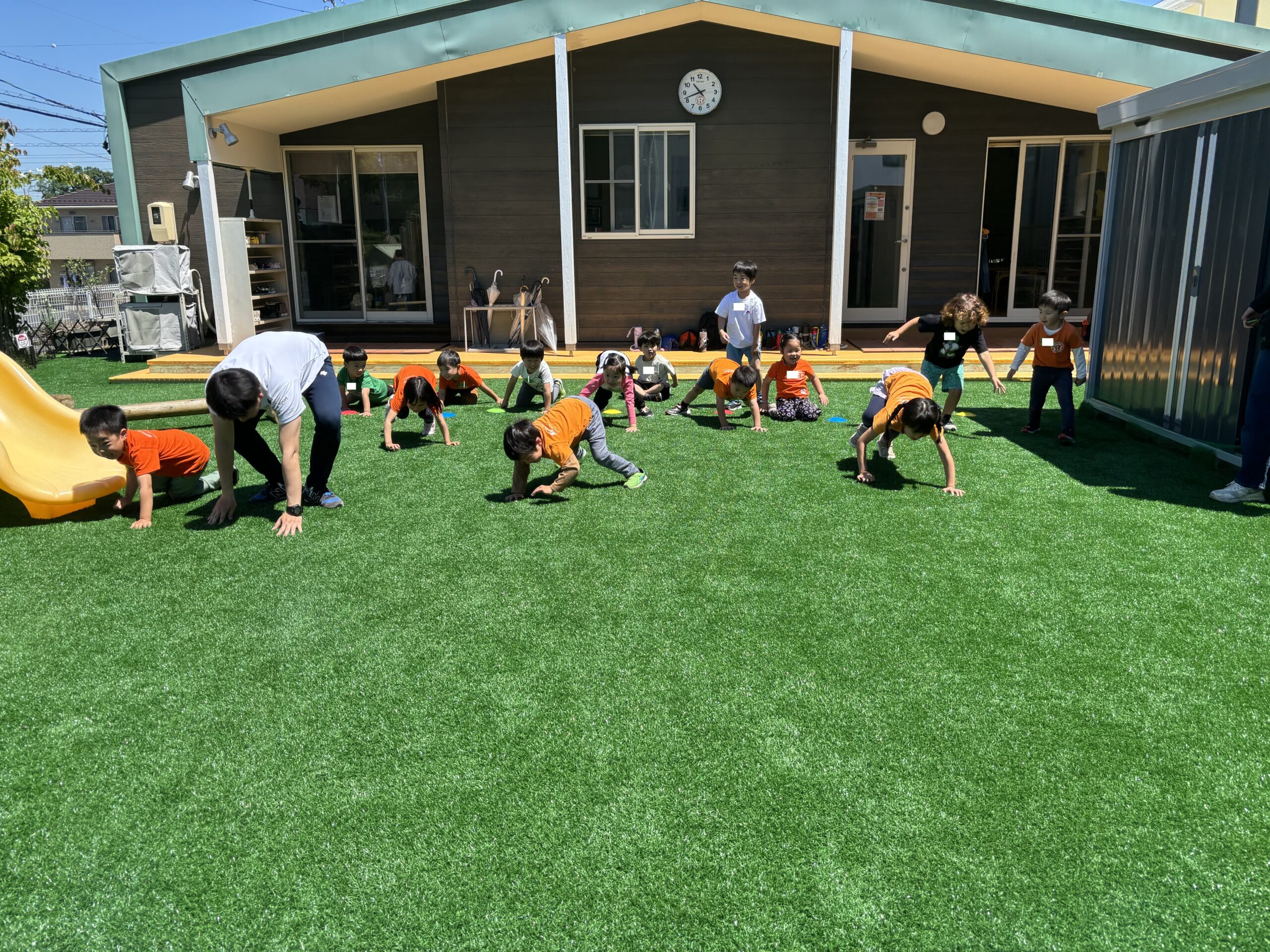 International school students practice crawling in the playground.