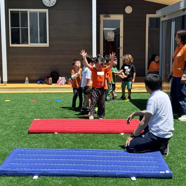 名古屋の屋外体操クラスでマット運動に取り組む園児たち 長久手のディスカバリーインターナショナルスクールで、体操エンリッチメントクラスのマット運動を順番に行う園児たちの様子。
