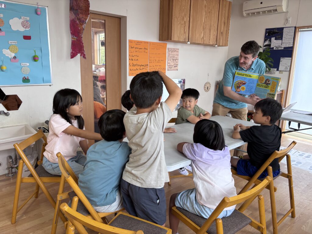 *after-school-english-community Children actively discussing an English text in Nagakute